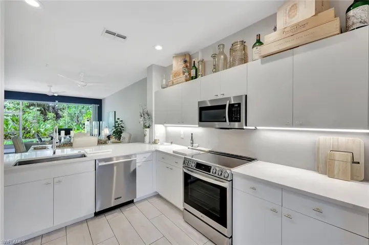 Kitchen featuring appliances with stainless steel finishes, light countertops, white cabinets, and recessed lighting