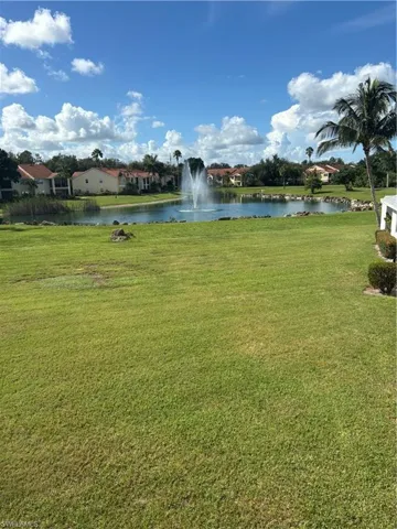 View of green lawn with a water view and a residential view