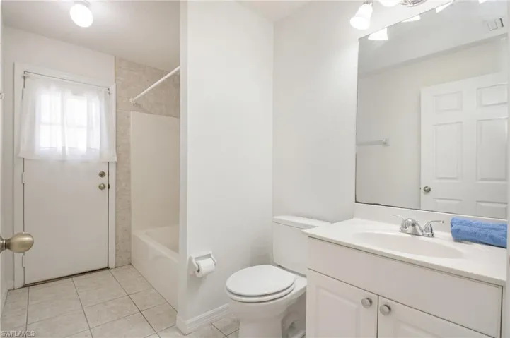 Bathroom featuring a white vanity with an integrated sink, polished chrome faucet, and a wall-mounted mirror