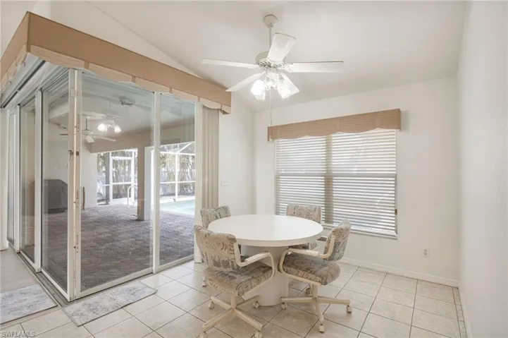 Tiled flooring extending to sliding glass doors with an awning, leading to an outdoor screened patio with paver flooring