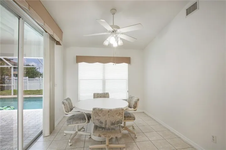 Interior dining space featuring tile flooring and a vaulted ceiling
