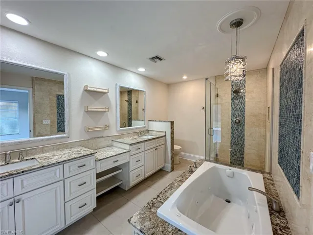 Master bath with dual sinks, vanity space, jetted tub and walk in shower