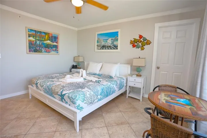 Tiled bedroom featuring crown molding and ceiling fan