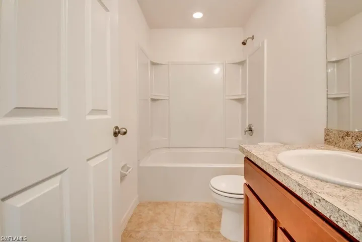 Full bathroom featuring vanity, toilet, tile patterned floors, and shower / bath combination