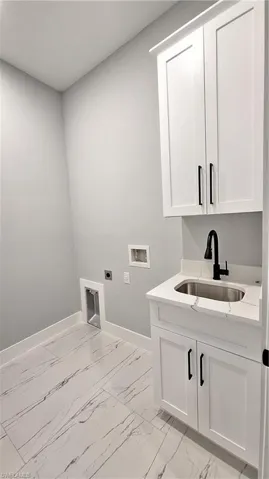Washroom with washer hookup, cabinets, sink, and electric dryer hookup