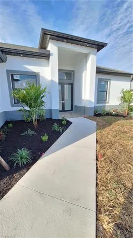 Doorway to property featuring stucco siding