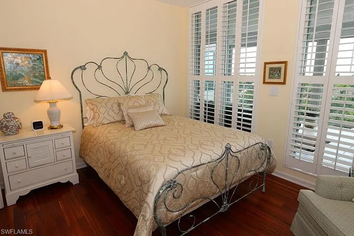 Hardwood flooring complements a decorative metal bed frame