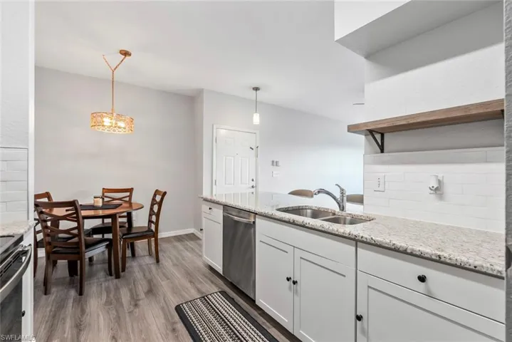 Kitchen with light wood-style flooring, a sink, stainless steel appliances, and tasteful backsplash