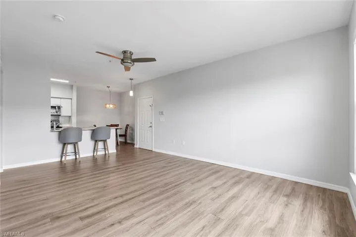 Living area featuring a ceiling fan, baseboards, and light wood-type flooring