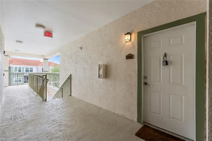 Doorway to property featuring a balcony and stucco siding