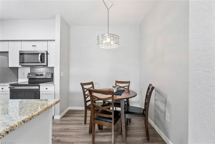 Dining room featuring an inviting chandelier, baseboards, and light wood-type flooring