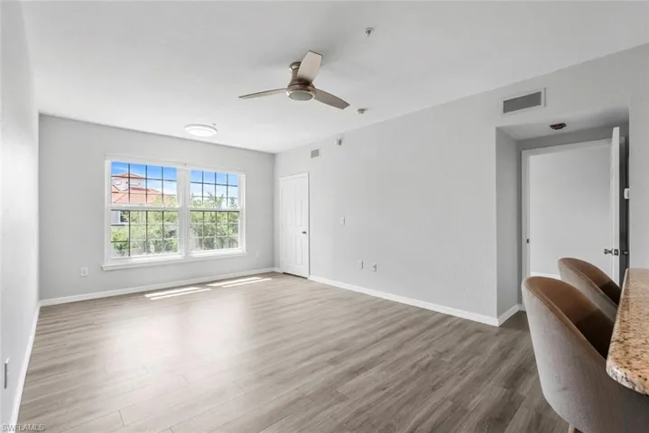 Spare room with baseboards, visible vents, wood finished floors, and ceiling fan