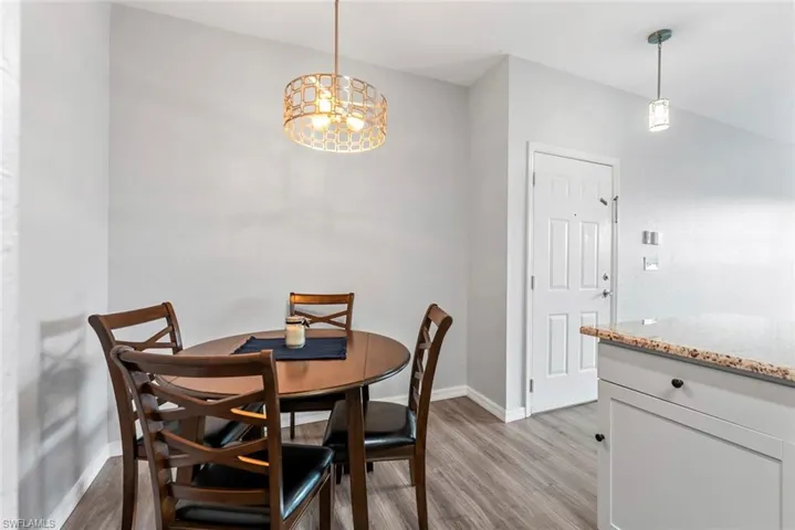 Dining area with an inviting chandelier, baseboards, and light wood-type flooring