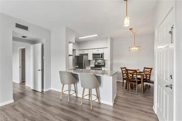 Kitchen featuring visible vents, white cabinets, light wood-style floors, and appliances with stainless steel finishes