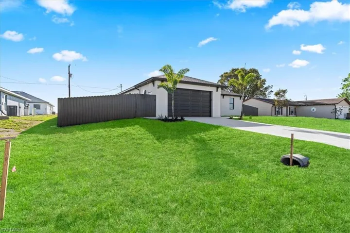 View of front of home with concrete driveway, stucco siding, and an attached garage