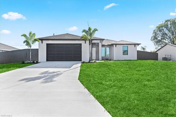 Prairie-style home featuring driveway, stucco siding, and an attached garage