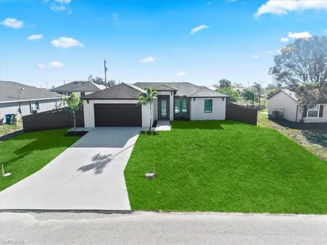 View of front of home featuring driveway, stucco siding, an attached garage, and a shingled roof