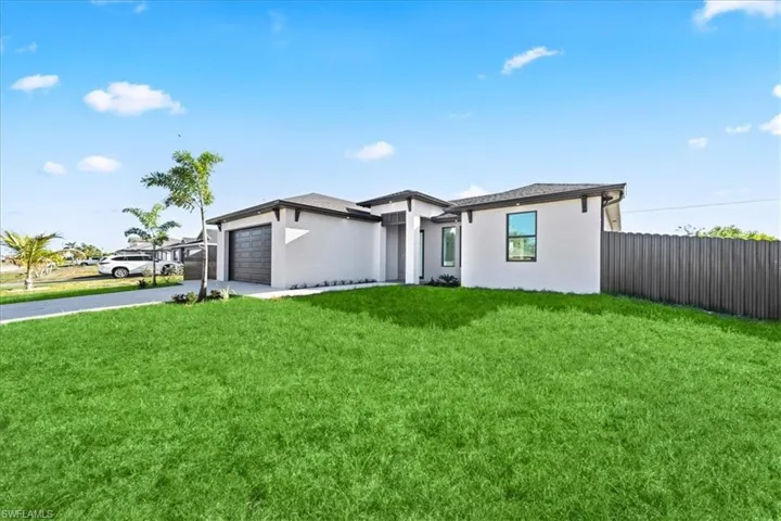 Prairie-style home with concrete driveway, stucco siding, and an attached garage