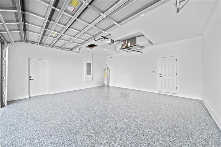 Garage featuring water heater and electric panel