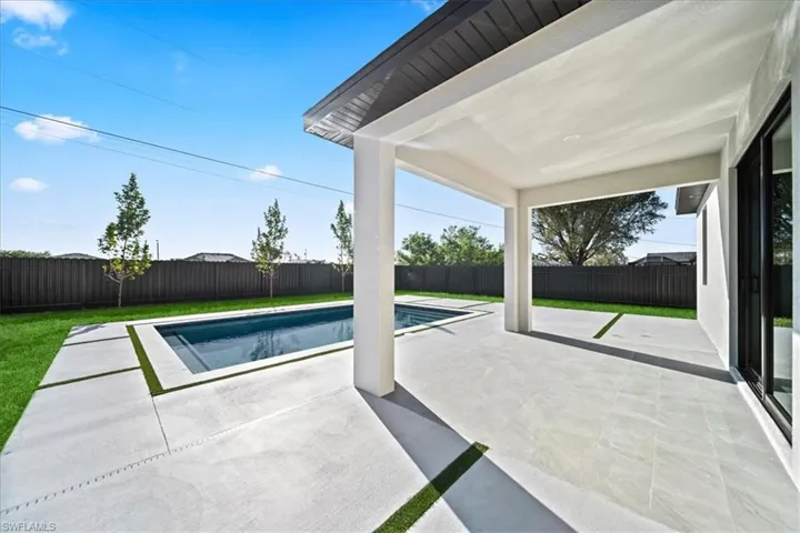 View of swimming pool with patio surround and a fenced backyard