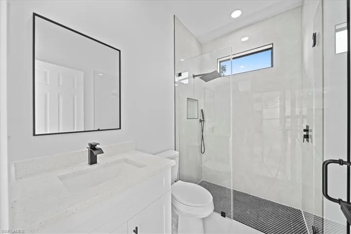 Bathroom featuring a shower stall, vanity, and recessed lighting