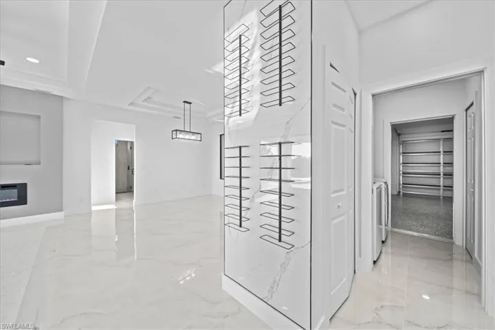View of home's community featuring a glass covered fireplace, a tray ceiling, independent washer and dryer, and recessed lighting