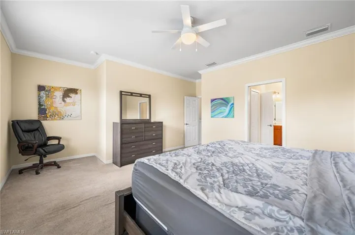 Bedroom featuring ornamental molding, ceiling fan, connected bathroom, and carpet flooring