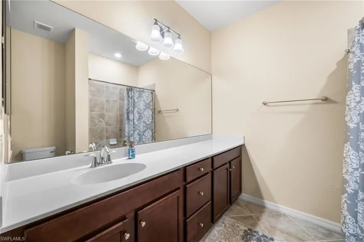 Bathroom featuring vanity, tile patterned flooring, and toilet