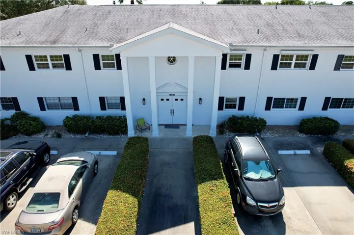 View of front of home with a shingled roof and uncovered parking