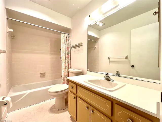 Full bath with vanity, shower / tub combo, and light tile patterned floors