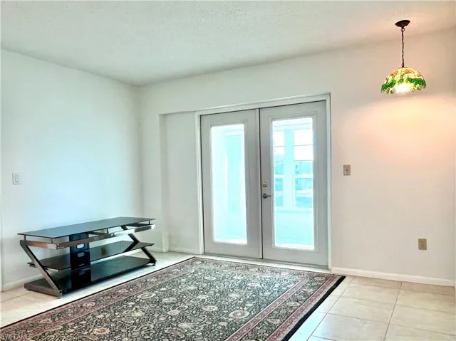 Entryway featuring french doors, tile patterned flooring, and a textured ceiling