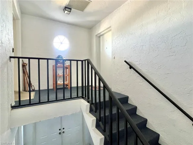 Stairs featuring a textured wall
