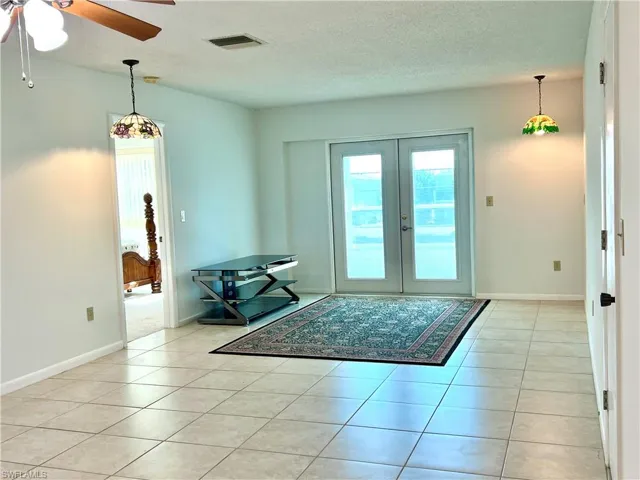 Entryway with ceiling fan, french doors, tile patterned floors, and a textured ceiling