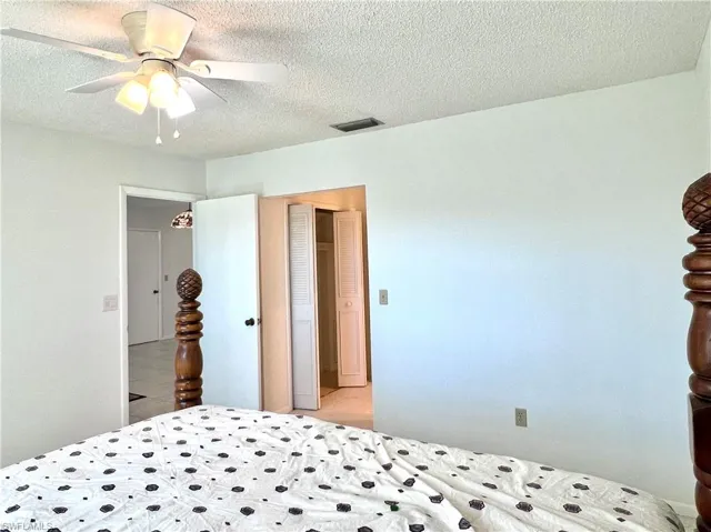 Bedroom featuring a textured ceiling and a ceiling fan
