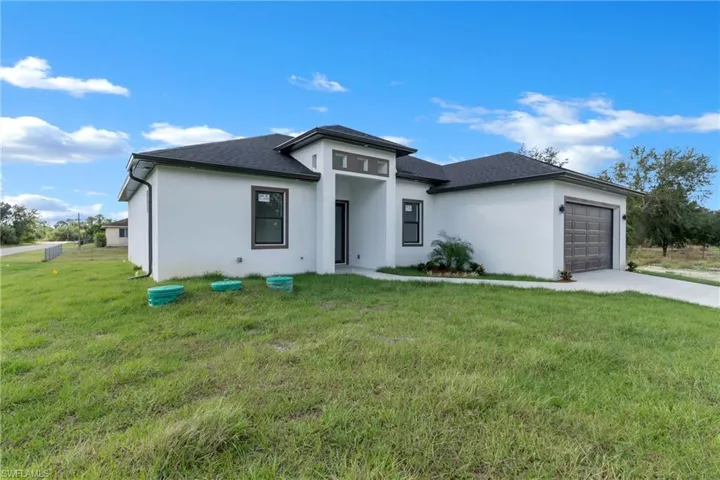 Prairie-style home featuring a garage and a front lawn