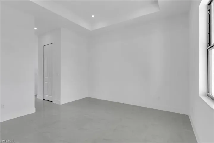 Empty room featuring a raised ceiling