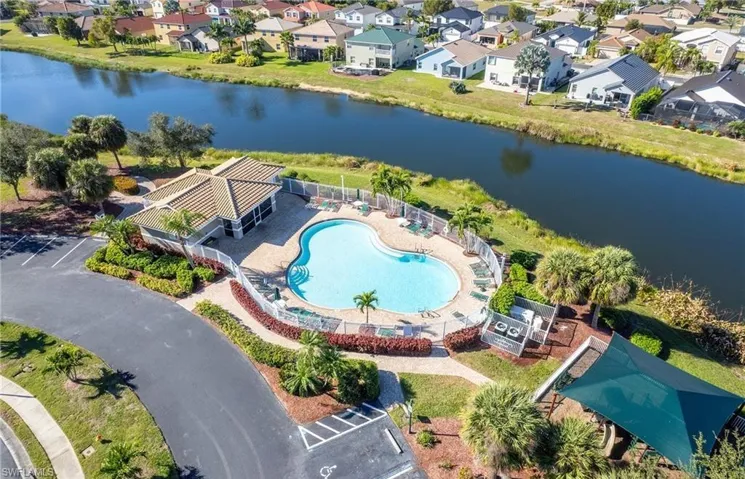 Aerial view of residential area with a pool area and a large body of water