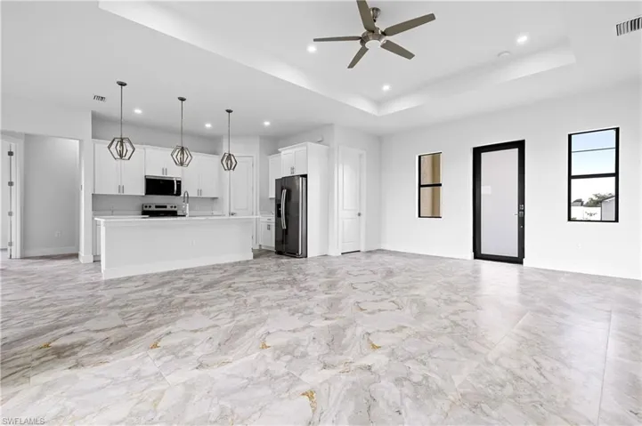 Kitchen with stainless steel microwave, fridge with ice dispenser, open floor plan, electric stove, and recessed lighting