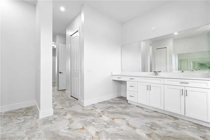Full bath featuring vanity and marble finish floors