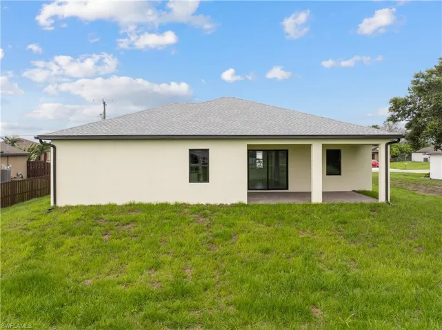 Rear view of house with a patio, stucco siding, and roof with shingles