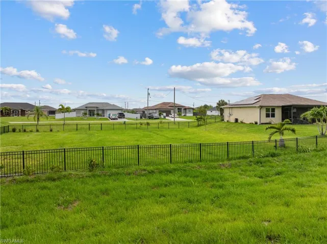 Fenced backyard featuring a residential view