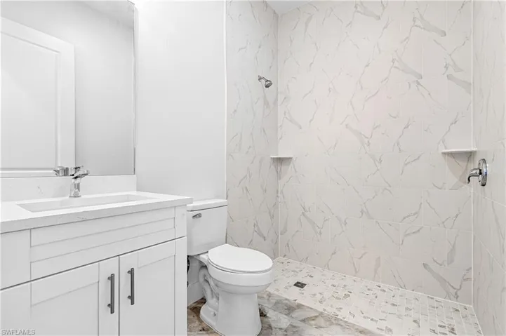 Full bath featuring vanity and a tile shower