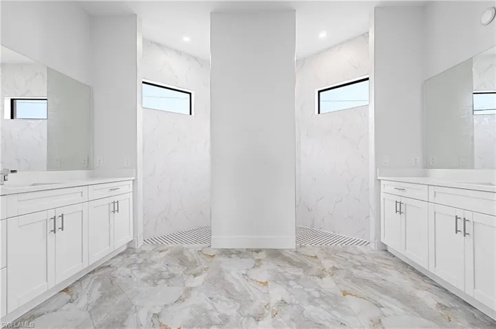 Full bathroom featuring marble tiled floors, a marble finish shower, healthy amount of natural light, and recessed lighting
