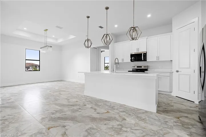 Kitchen with appliances with stainless steel finishes, light marble finish floors, white cabinetry, recessed lighting, and light countertops