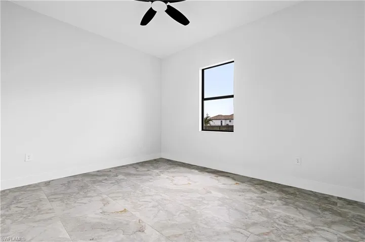 Unfurnished room featuring marble finish floors and ceiling fan