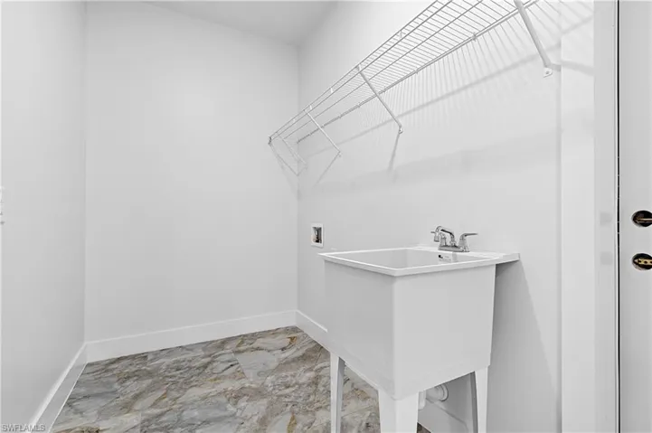 Laundry room featuring hookup for a washing machine and light marble finish floors