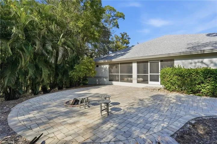 View of patio featuring an outdoor fire pit and a sunroom