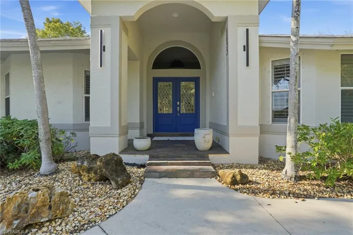Doorway to property featuring stucco siding, french doors, and covered porch