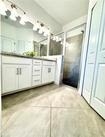 Bathroom with a shower stall, double vanity