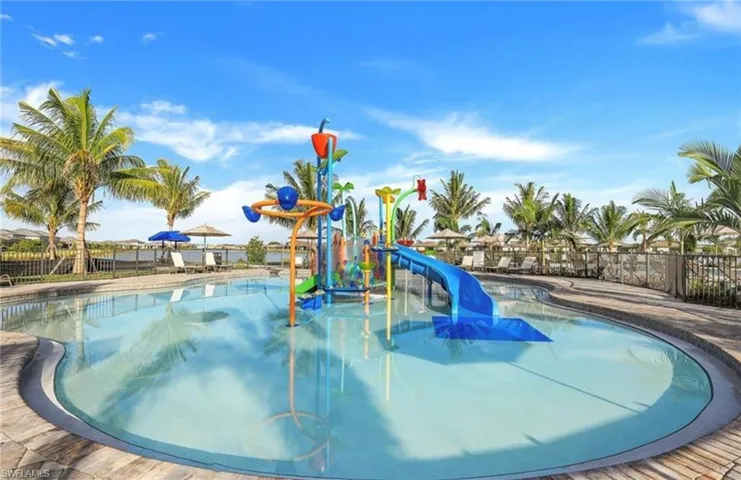 Community pool featuring a water play area, a water slide, and a patio area